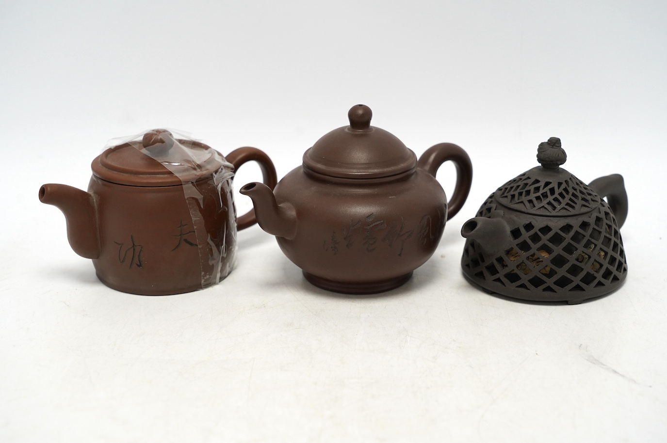Three Yixing teapots, one double walled lattice worked body, tallest 11cm. Condition - good